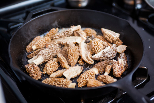 Morels simmering away in an iron skillet. Possibly sautéing in an iron skillet. I'm not sure what you'd say exactly but it's definitely morel mushrooms.