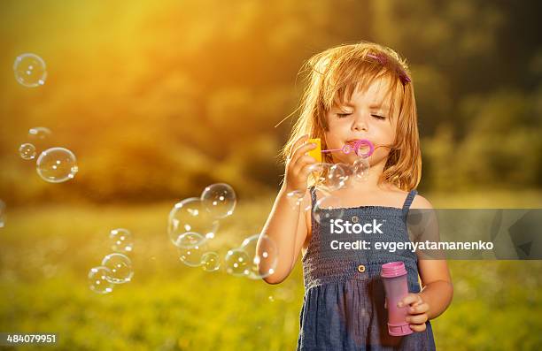 Little Girl Soplando Burbujas De Jabón En La Naturaleza Foto de stock y más banco de imágenes de Soplador de burbujas de jabón
