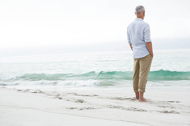 istock Thoughtful man standing by the sea 484080218