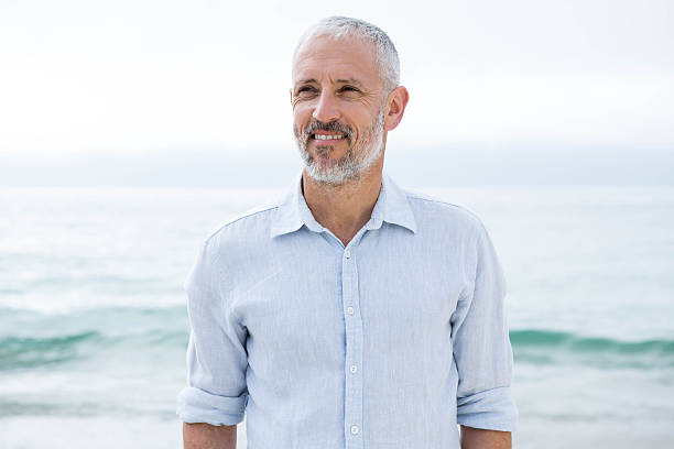 istock Smiling man standing by the sea 484080224