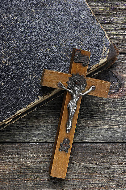 istock Cross and old book on wooden table 484081003