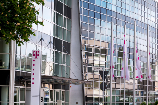 Bonn, Germany - April, 16th 2011: Building of Deutsche Telekom in Bonn. In front of building is logo and some flags at right side.