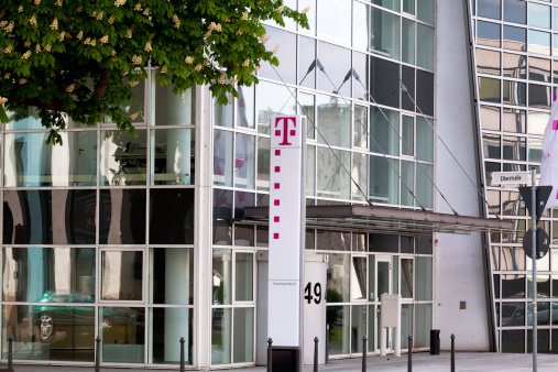 Bonn, Germany - April, 16th 2011: Company and office building of Deutsche Telekom in Bonn. In front of building is logo and some flags at right side.
