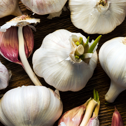 Some garlic bulbs on a wooden board