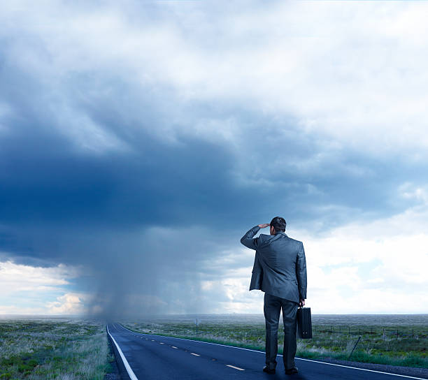 istock Businessman Looking Down Road At Rainstorm 484087610