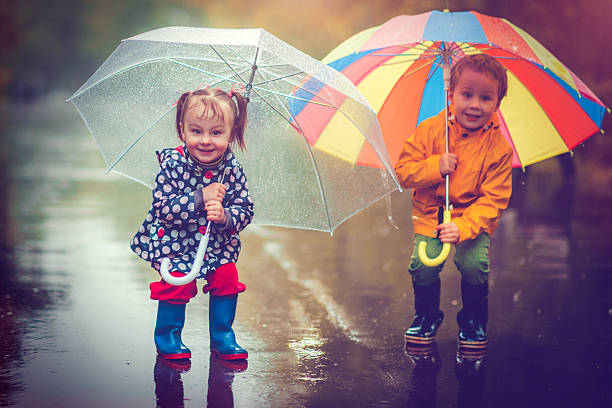 istock Little boy and girl in rain 484092074