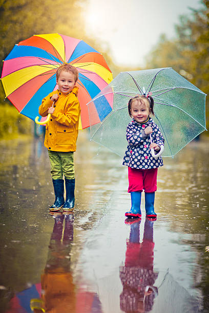 istock Little boy and girl in rain 484092094