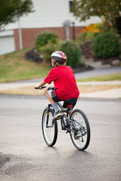 istock Young Boy Riding Bicycle On Street 484095462