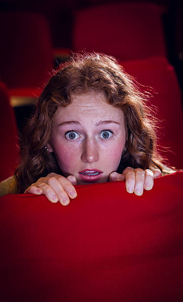 istock Young woman watching a scary film 484095940