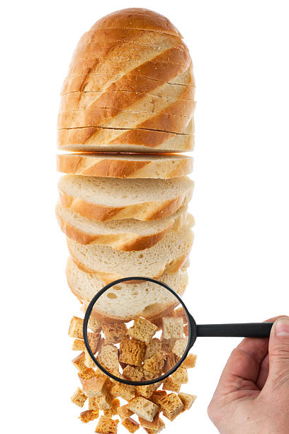 istock Human hand holding a magnifying glass over the bread 484101027