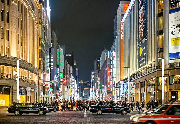 A busy intersection at night in the Ginza area of Tokyo, Japan.