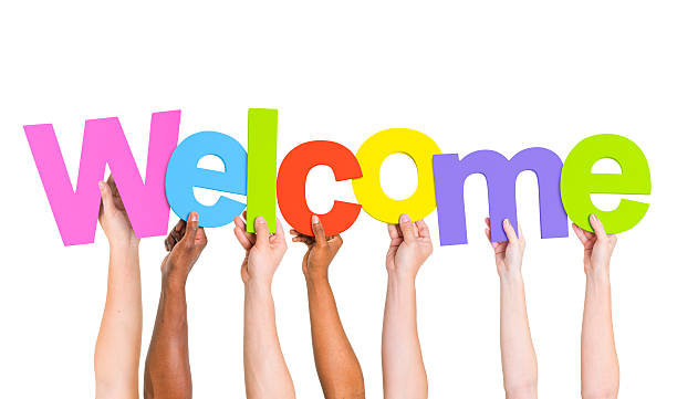 grupo multiétnico de gente que sujeta la palabra bienvenido - welcome fotografías e imágenes de stock