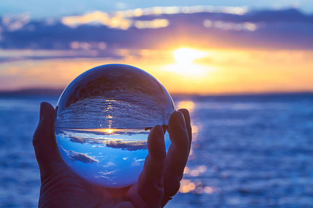 crystal ball The sun sets over Lake Constance in Germany and lit by a crystal ball. dawn of new era stock pictures, royalty-free photos & images