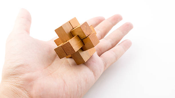 istock Hand holding piece of wooden block cube puzzle. 484104344