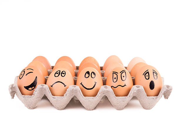 istock Funny faces painted on brown eggs in a tray 484105179