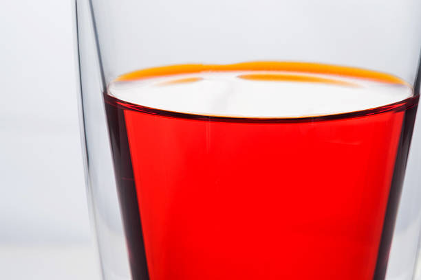Glass of red water, like a tomato juice, carrot juice, soft drink
