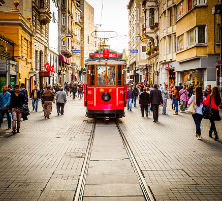 Istanbul, Turkey - November 23, 2013: Street car makes its way alongside shoppers crowding İstiklal Avenue. Known in English as Independence Avenue, the most famous shopping street in the country sees as many as three million pedestrians on a busy weekend day.