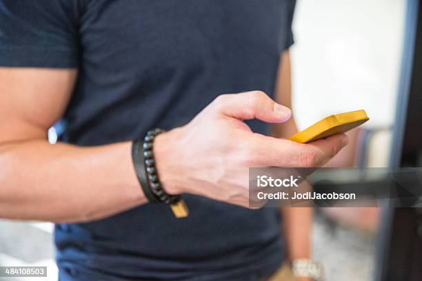 Man Looks At His Cell Phone Stock Photo - Download Image Now - Adult, Adults Only, Bicep