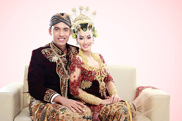 traditional java wedding couple traditional java wedding couple husband and wife in the couch sitting together indonesian ethnicity stock pictures, royalty-free photos & images