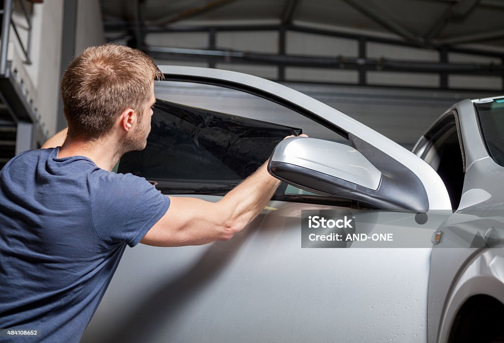 Aplicar tinting de lámina en una ventana de coche - Foto de stock de Coche libre de derechos