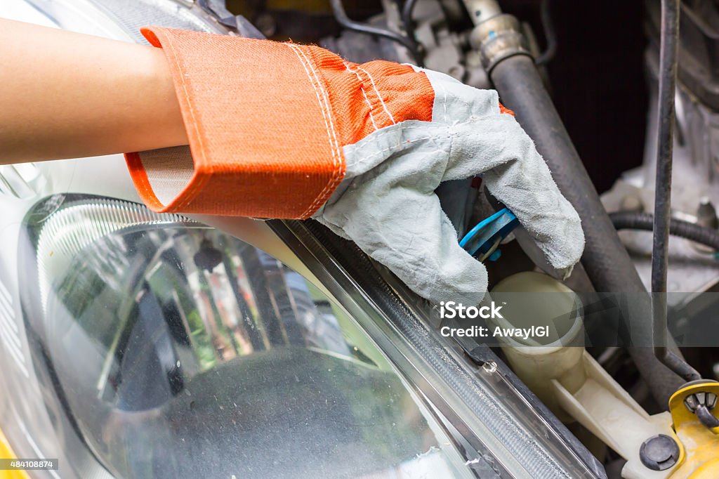 car mechanic in his repair car mechanic in his repair shop standing next to the car - close-up of the engine 2015 Stock Photo