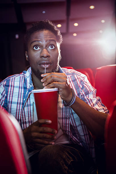 istock Young man watching a film and drinking soda 484108992