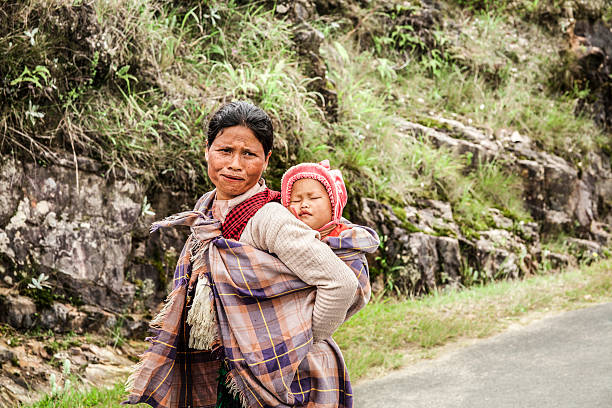 indyjski kobieta z khasi tribe przewożących dzieci w podróży. - india women ethnic indigenous culture zdjęcia i obrazy z banku zdjęć