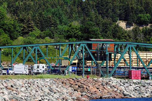 Canso Causeway, Canada – August 6, 2015: The swing bridge on the Canso Causeway allows a ship to pass through and blocking traffic from entering Cape Breton Island in Nova Scotia.  The causeway was built with rock from nearby Cape Porcupine.