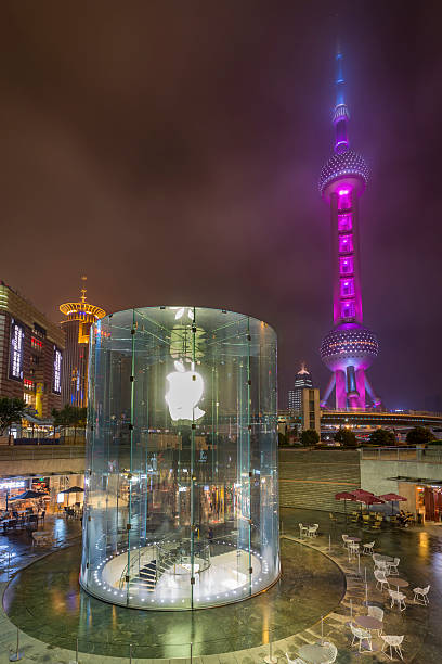 Shanghai, China - June 7, 2015: The Oriental Pearl Tower, symbol of socialist architecture and a Apple Store, symbol of the modern china at night 