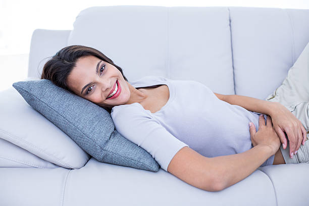istock Smiling beautiful brunette relaxing on the couch 484119030