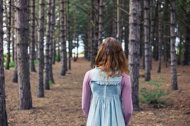 istock Woman standing in forest and looking at trees 484119270