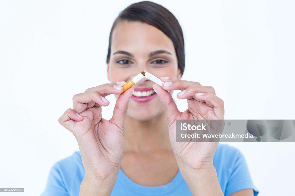 Happy woman breaking a cigarette Happy woman breaking a cigarette on white background 20-24 Years Stock Photo