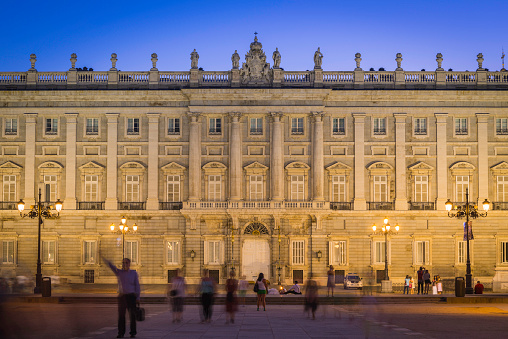 Madrid, Spain - July 12, 2015: People enjoying the warm summer evening in the Plaza de Oriente overlooked by the ornate facade of the Palacio Real in the heart of Madrid, Spain's vibrant capital city. 