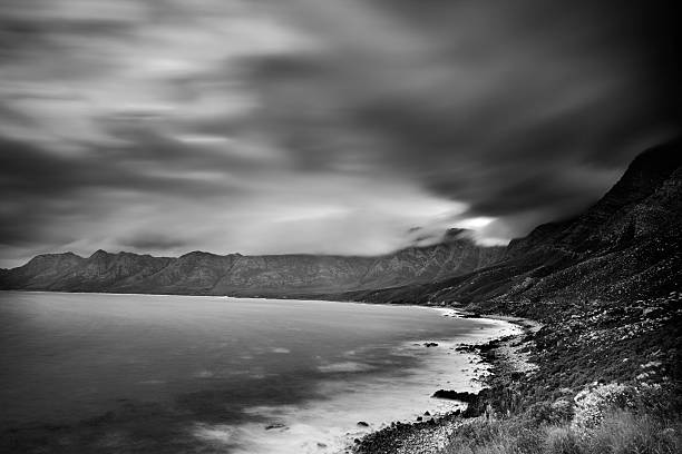 Clarence Drive A long exposure B&W view of the scenic Clarence Drive (R44), a coastal route between Gordons Bay and Kleinmond in the Western Cape, South Africa. gordons bay stock pictures, royalty-free photos & images