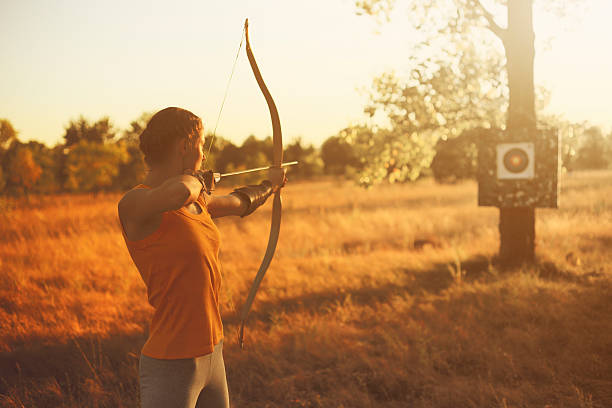 istock Female archer in the field at sunset 484131702