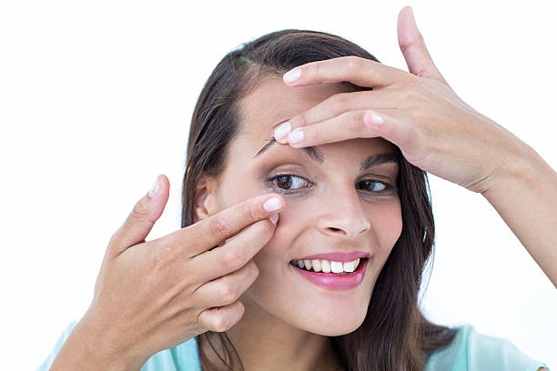 istock Beautiful woman applying contact lens 484132320