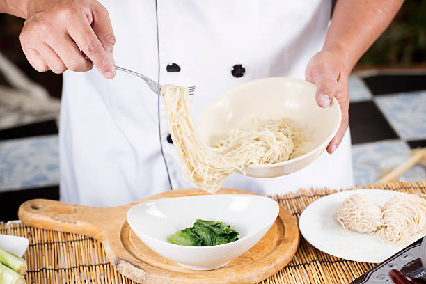 istock Chef holding the noodle from the bowl with fork 484132732