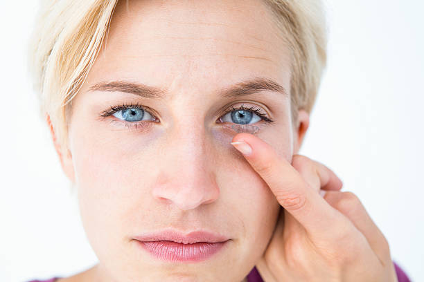 istock Pretty blonde applying contact lens 484133008