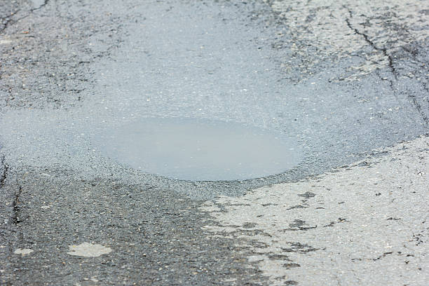 istock Very bad quality road with potholes and puddles 484133490