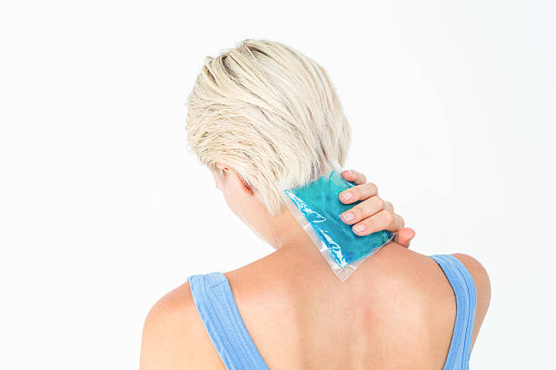 blonde frau putting-gel-packung auf nacken - ice women ice pack physical injury stock-fotos und bilder