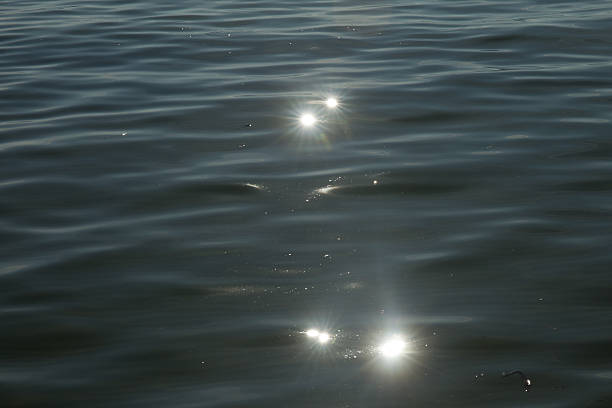 istock Abstract background of ripples on water surface and sun reflection 484137696