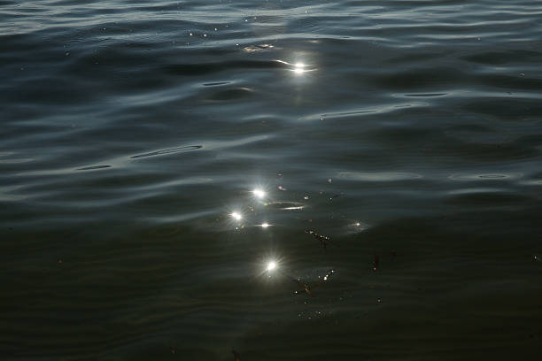 istock Abstract background of ripples on water surface and sun reflection 484137698