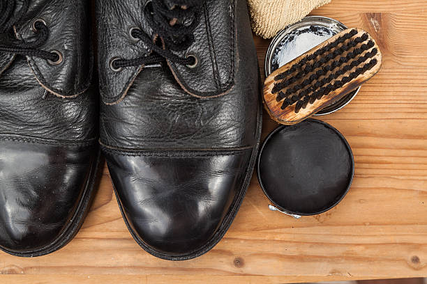 istock Shoe polish with brush, cloth and worn boots on platform 484138684