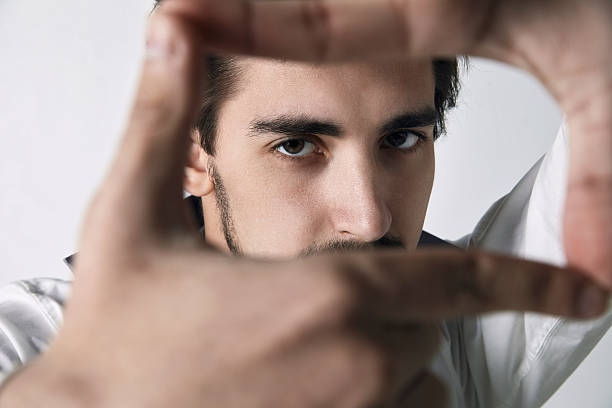 istock Closeup of young man framing photograph 484140232