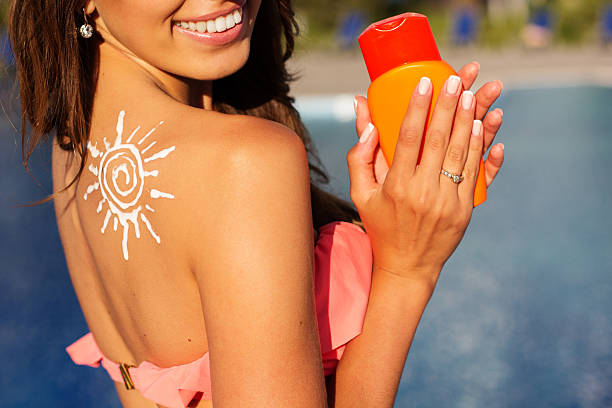 istock Girl with sun from sunscreen lotion on her shoulder 484146834