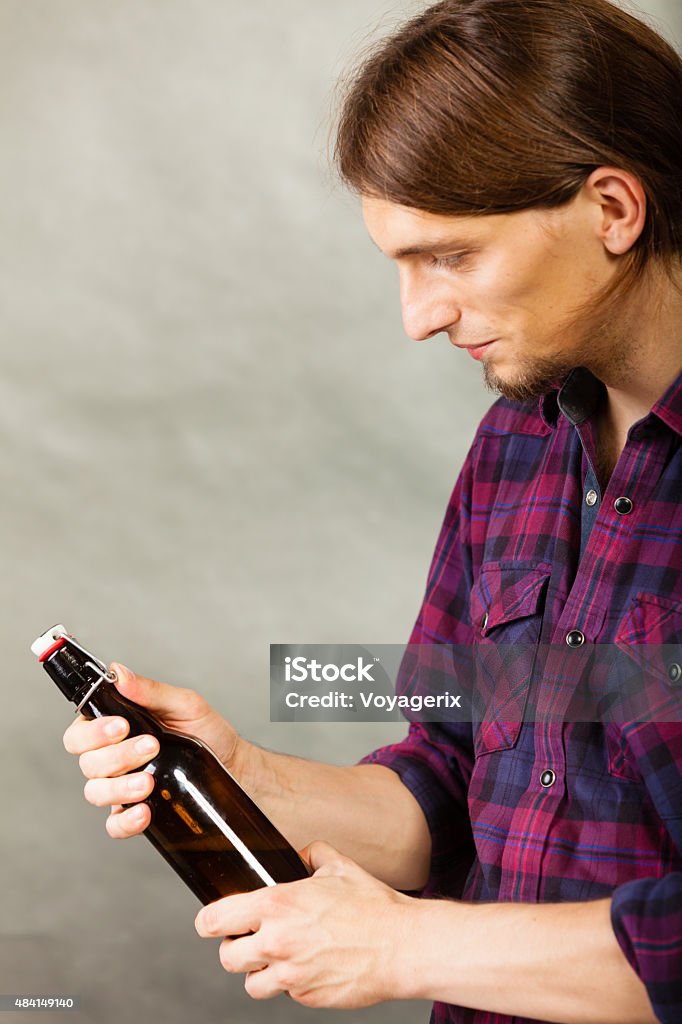 young man holding a beer bottle on grey young man holding a beer bottle on grey background 2015 Stock Photo
