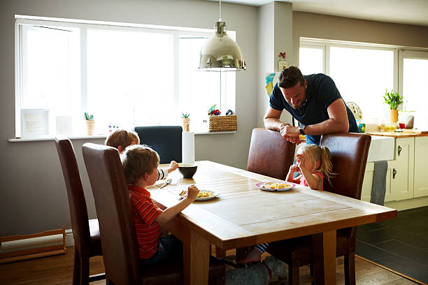 istock Three little kids having lunch with their father 484150068
