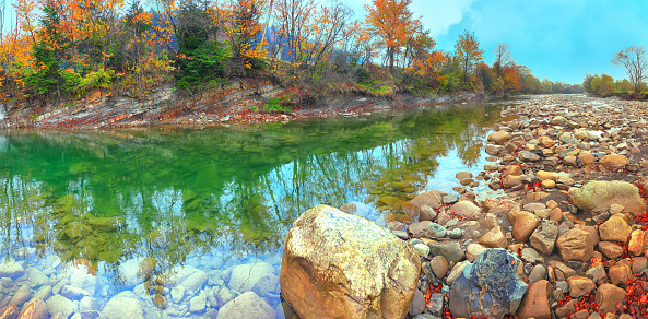 mountain river in autumn time. Rocky shore. Colourfull forest
