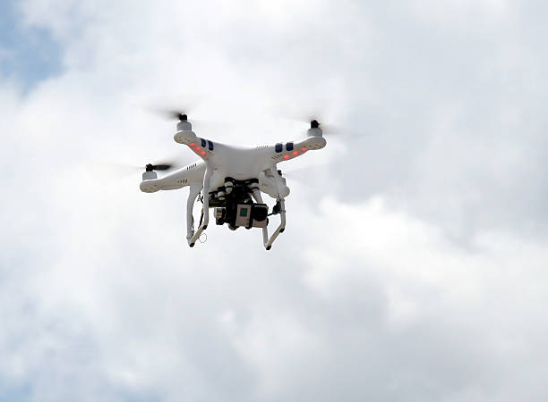 istock Drone with camera flying, against white clouds and blue sky. 484151486