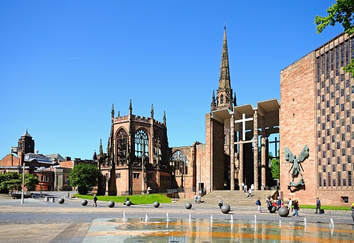Coventry, United Kingdom - June 4, 2015: View of the old and new Cathedrals with tourists passing by, Coventry, West Midlands, England, UK, Western Europe.